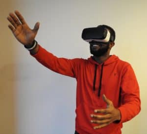 man wearing white VR headset while lifting right hand, virtual reality